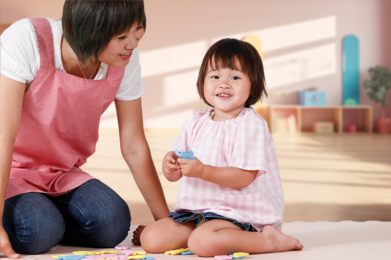 笑顔の女性スタッフと遊ぶ子供